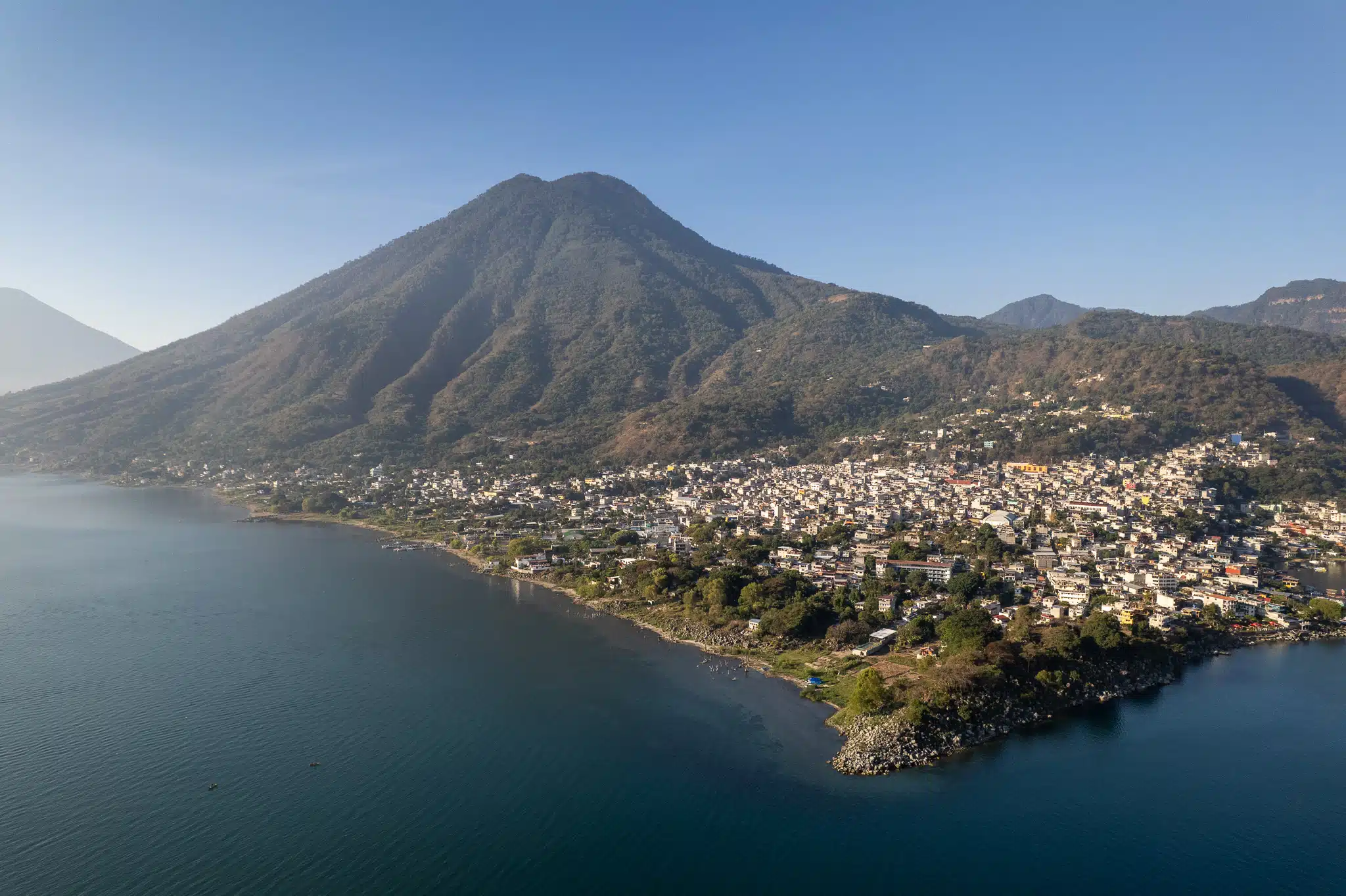 aerial view of san Pedro Pedro city and San PEdro Volcano in the backgorund, with the lake atitlan in the foreground. This is in Guatemala.