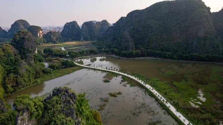 Road surrounded by lakes and rice field in Tam Coc