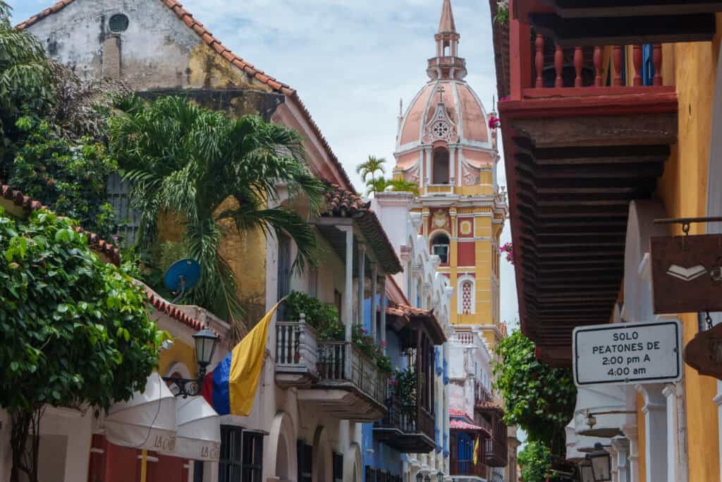 street in the cicty center of cartagena, with coloruf houses and the dromo in the background