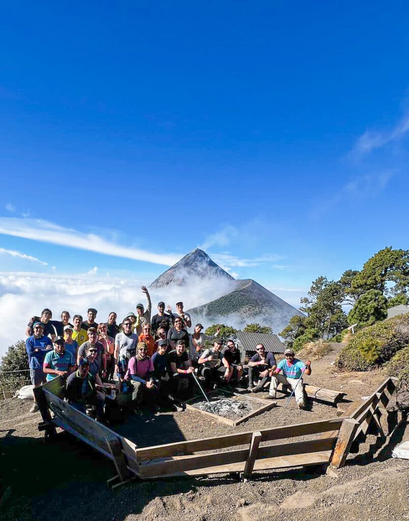 Group photo at the base camp of the Acatenango Fuego trek with fuego in the background