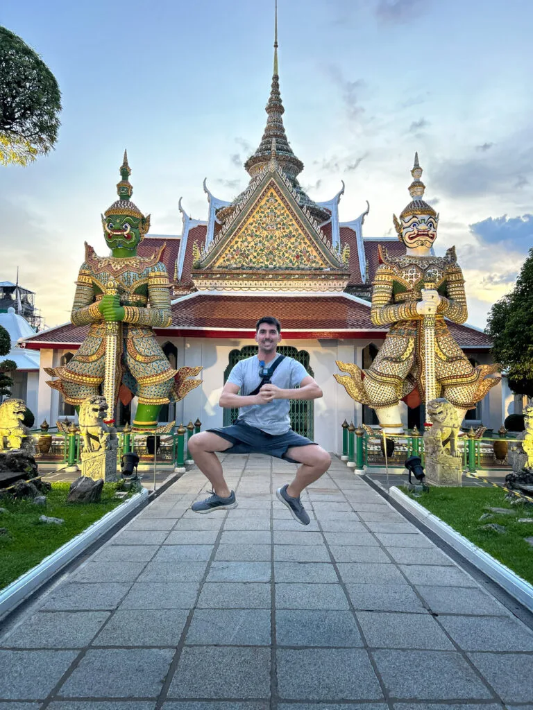 Me jumping in front of the Yaksha statues at Wat Arun temple in Bangkok, trying to imitate their style