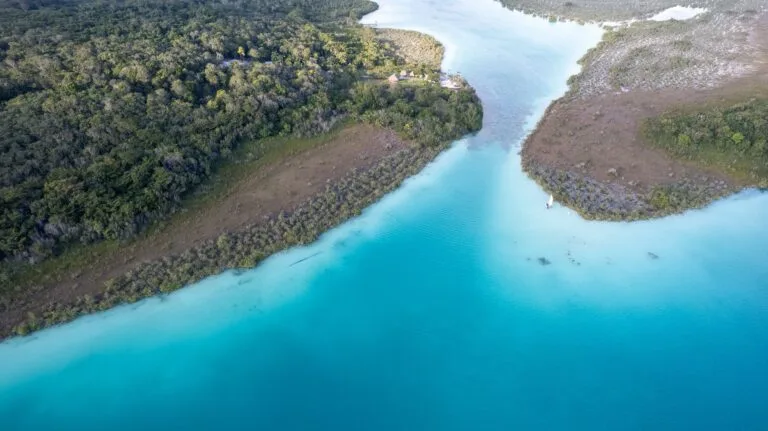 Aerial view of Baccalar lake with a beuatiful turquoise water, a boat next to the shore