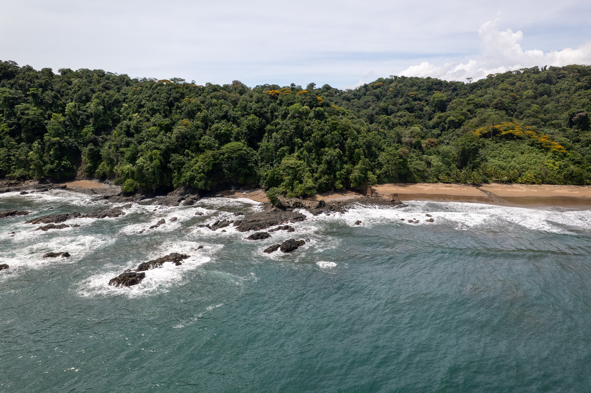 Aerial view of the beach near Bahia Solano with luxury jungle, brown sand and nobody around