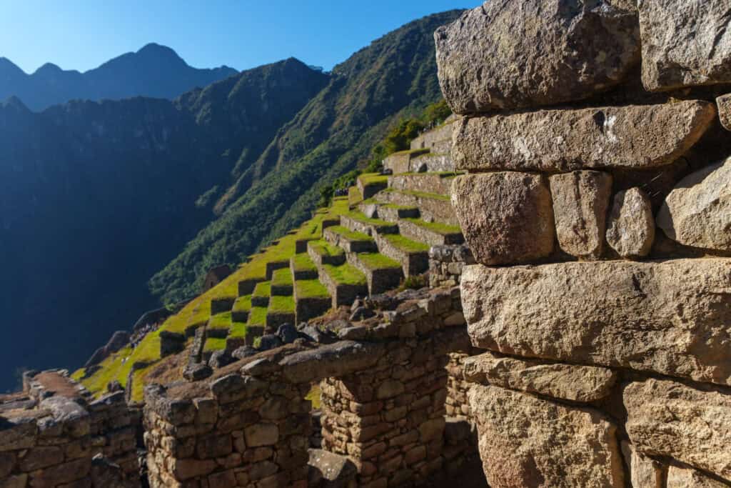 close-up of wall in machu picchu inca city with the terrace field in the background