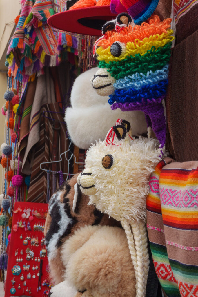 Street market in the city center of cusco with hats in a shape of llamas, some of them are white, some are colorful