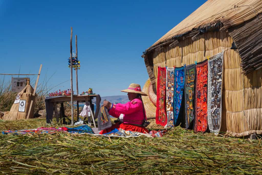 Uros women setting up it's hand made textitle to sell to tourists visiting her floating island on lake titicaca