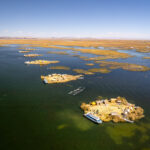 Aerial view of many floating island from Uros community with turists group on each of them visiting and discovering their lifestyle