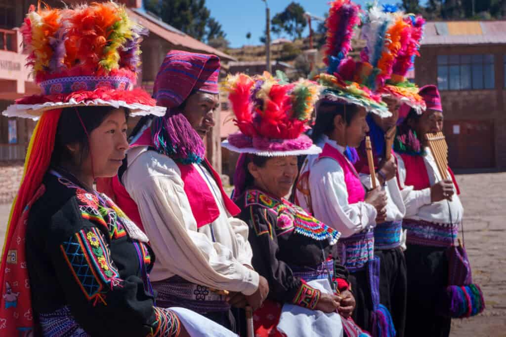 Pueruvian people from Taquile Island with traditional clothes waiting for tourist to come take pictures with them