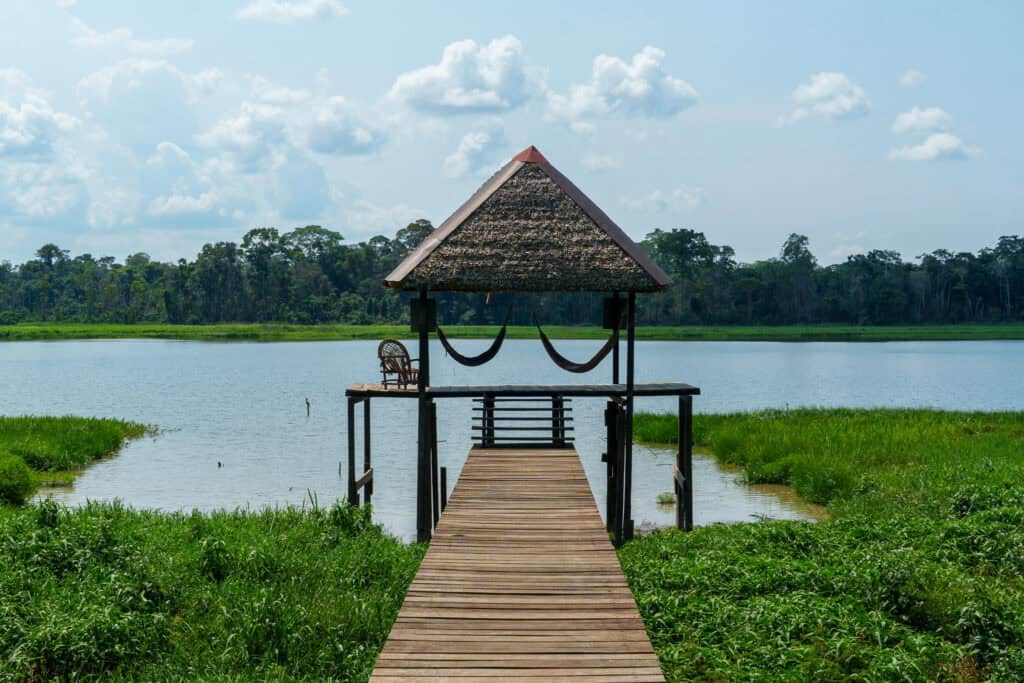 pontoon at sustainable bolivia on the san jose lake. there are two hammocs and a chair for people to relax and admire the landscape.