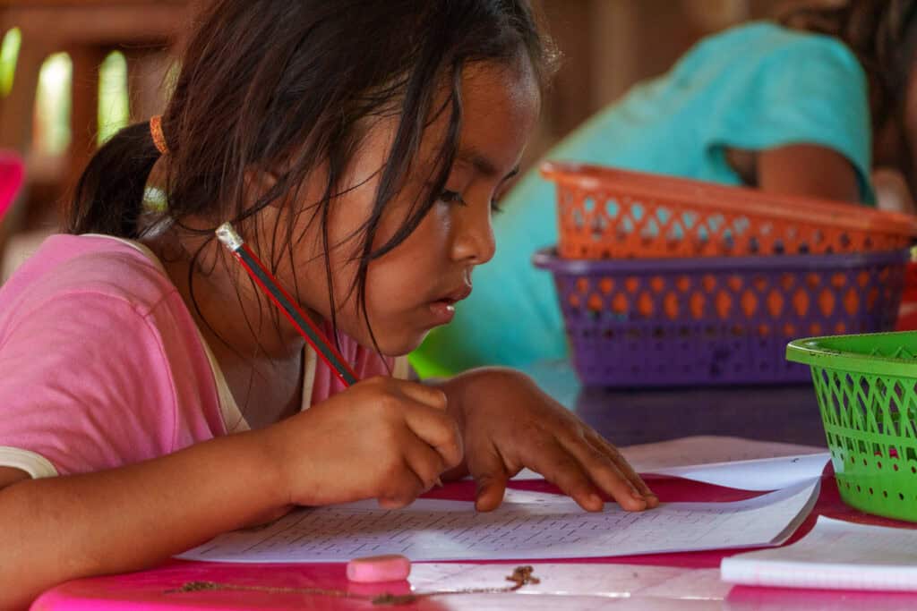 CLose-up of a young girl from Warnes during a class lessons from sustainable bolivia resolving a maze