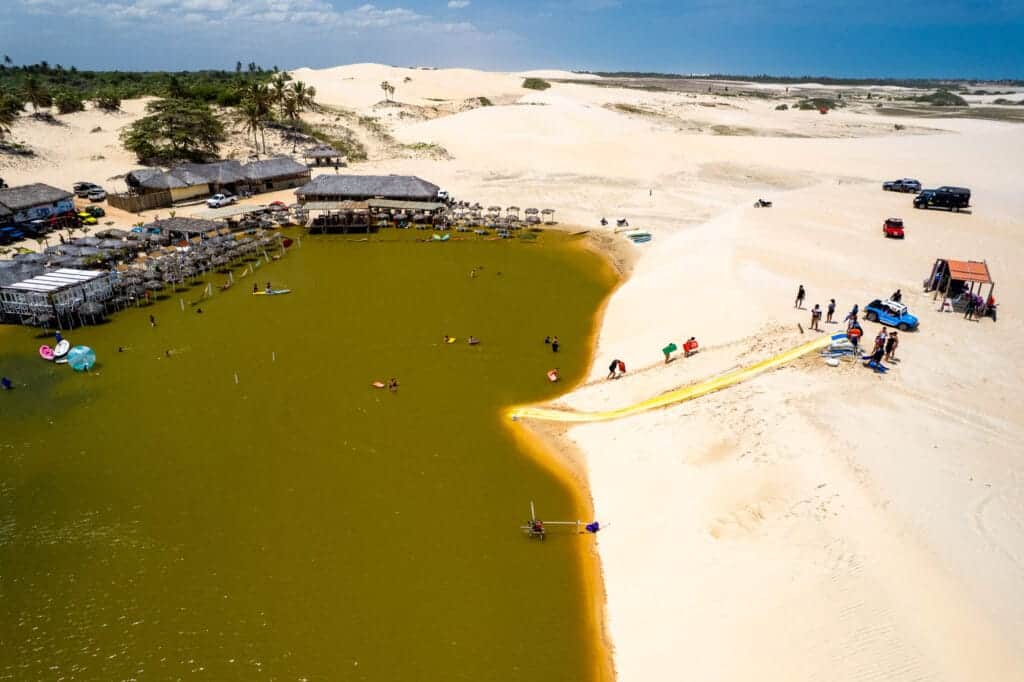 People doing slide from the top on the dune to the lagoon where the restaurants are located during the quad tour.