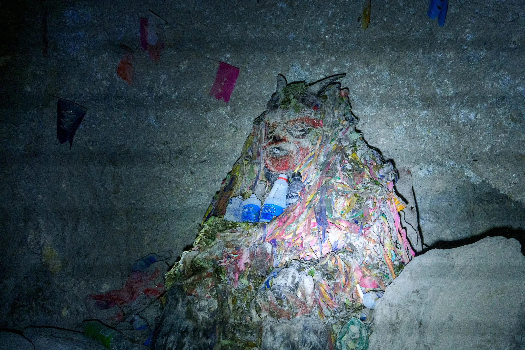 Stue of the spirit El Tio inside the mine. He's protecting the miners and for that miners do offrands, like turbans and alcool.