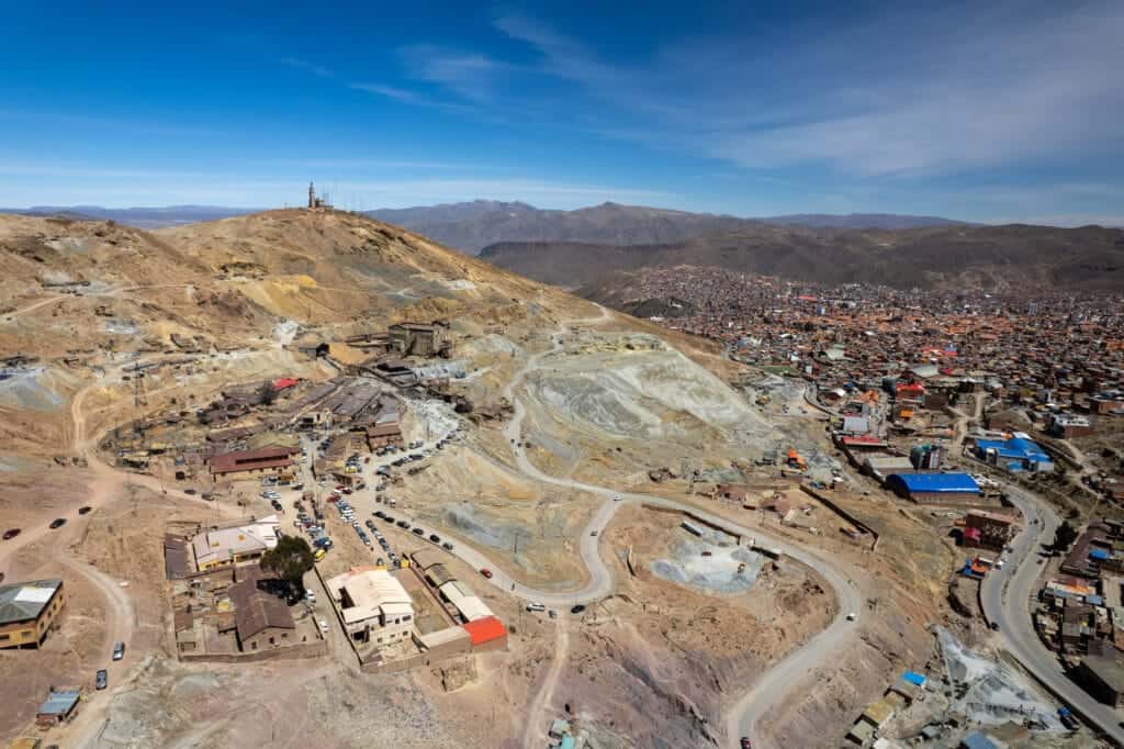 Drone view of Cerro Rico and the city of Potosi in the background. we can see the road leading to the entrances of the mines on the mountains.
