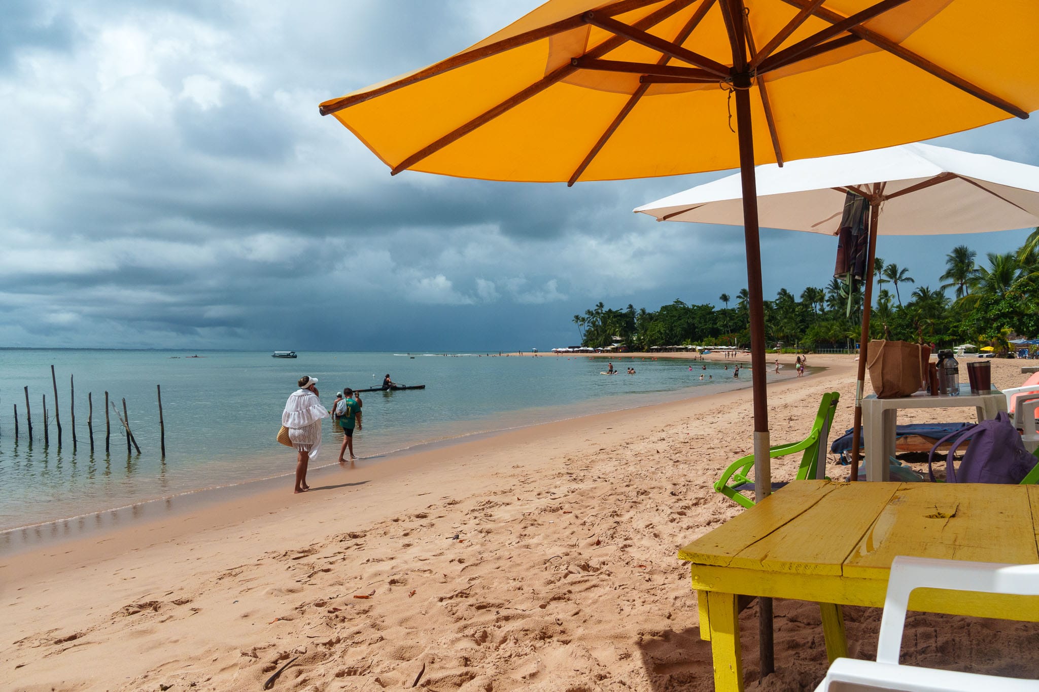 view from a restaurant at the main ebach at barra grande, marau, brazil. there is a storm in the background at the sea.