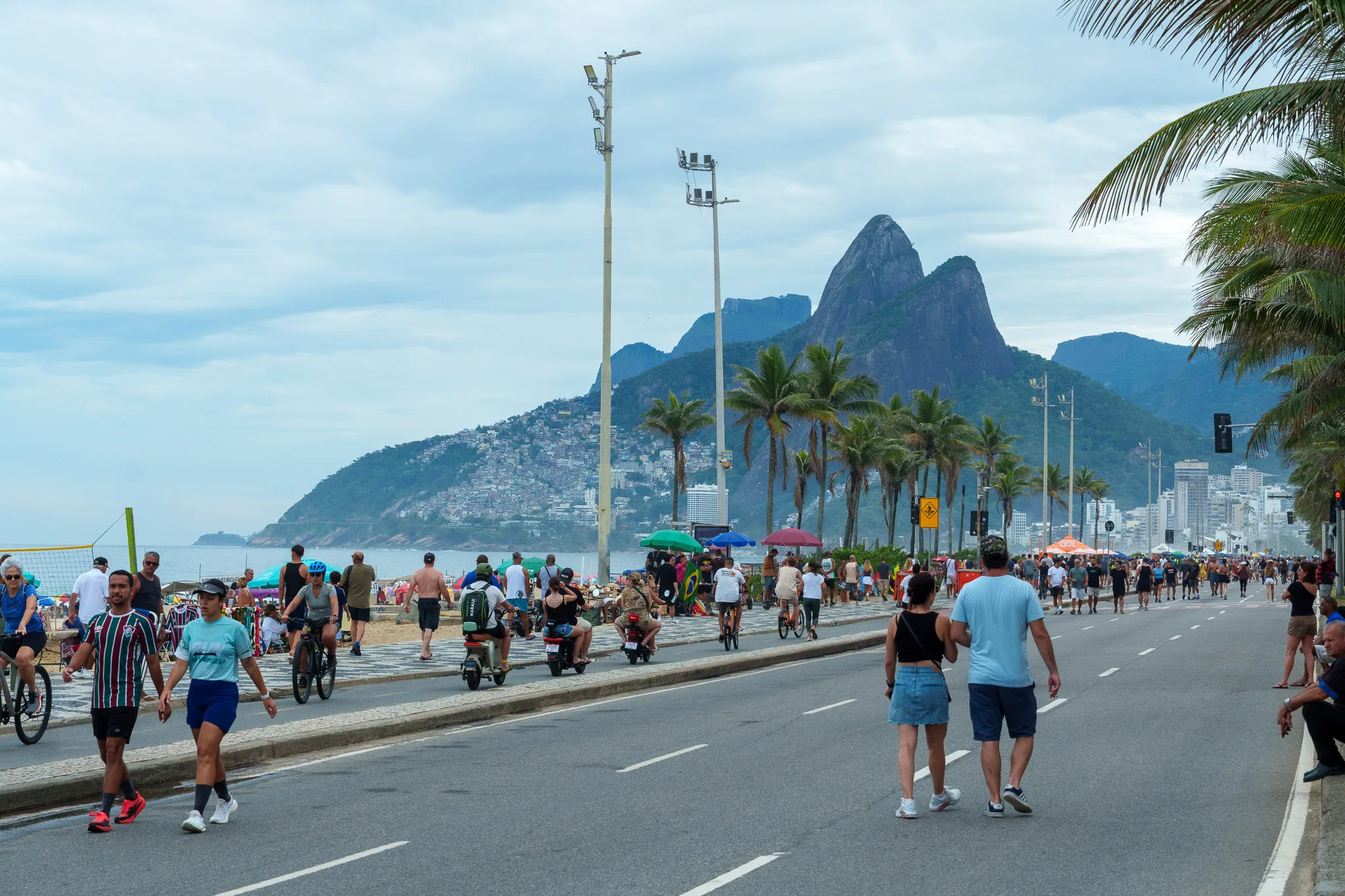View of Ipanema bay during Sunday. the highway is closed and people are walking and doing bike on the highway. we can see the mountains 