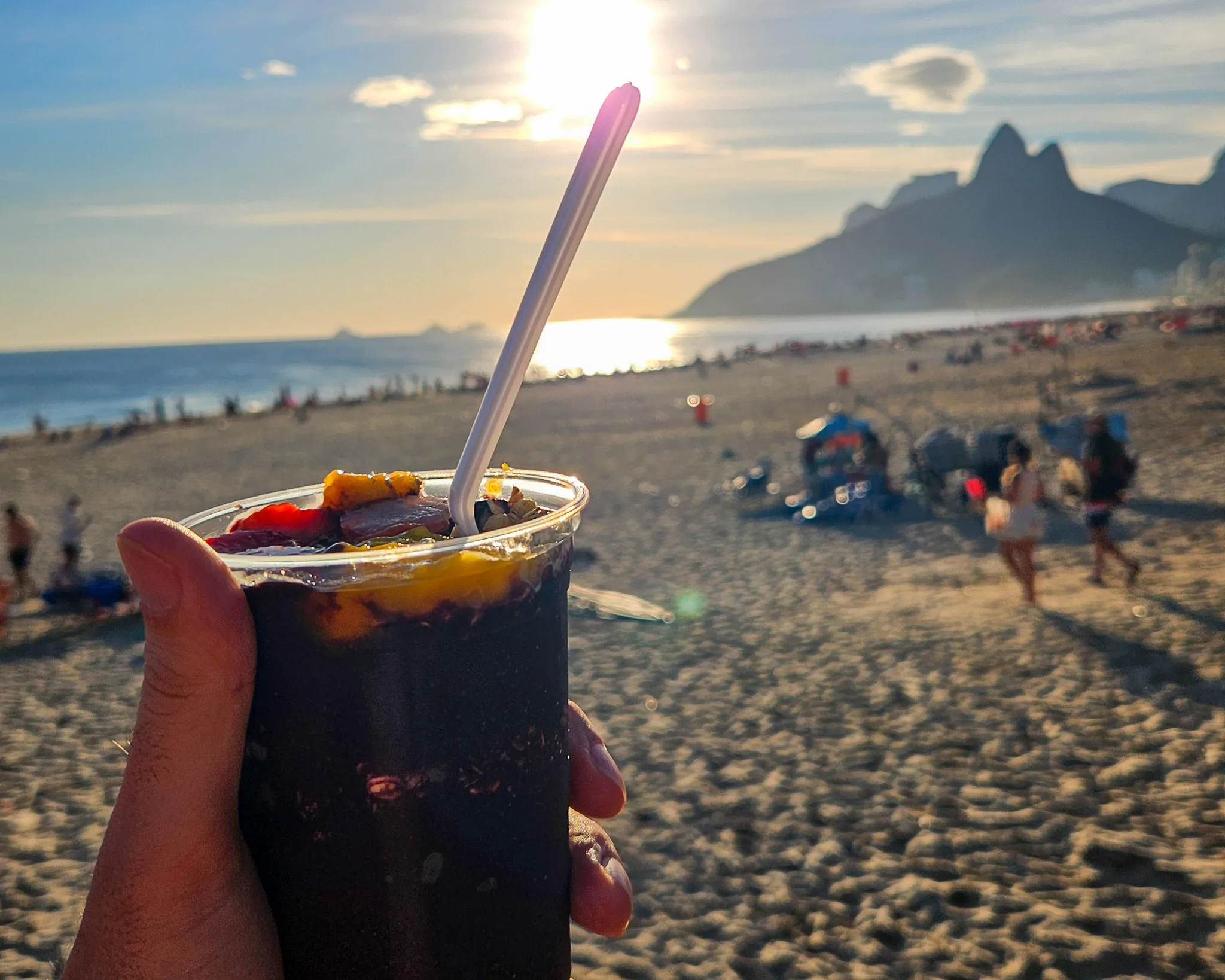 Cup of acai with fruits with ipanema beach in the background, Rio de Janeiro, Brazil.