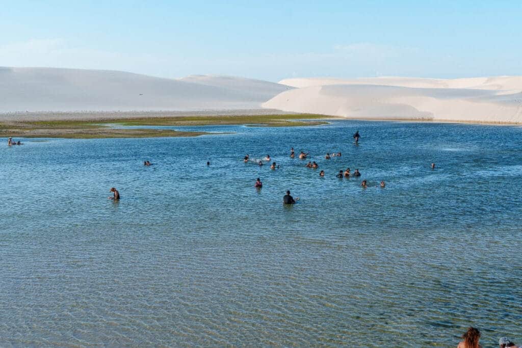 tourist at Lencois Maranhenses park take a swim in 'Lagoa Bonita'. it's january so the depth of the lagoon is small.