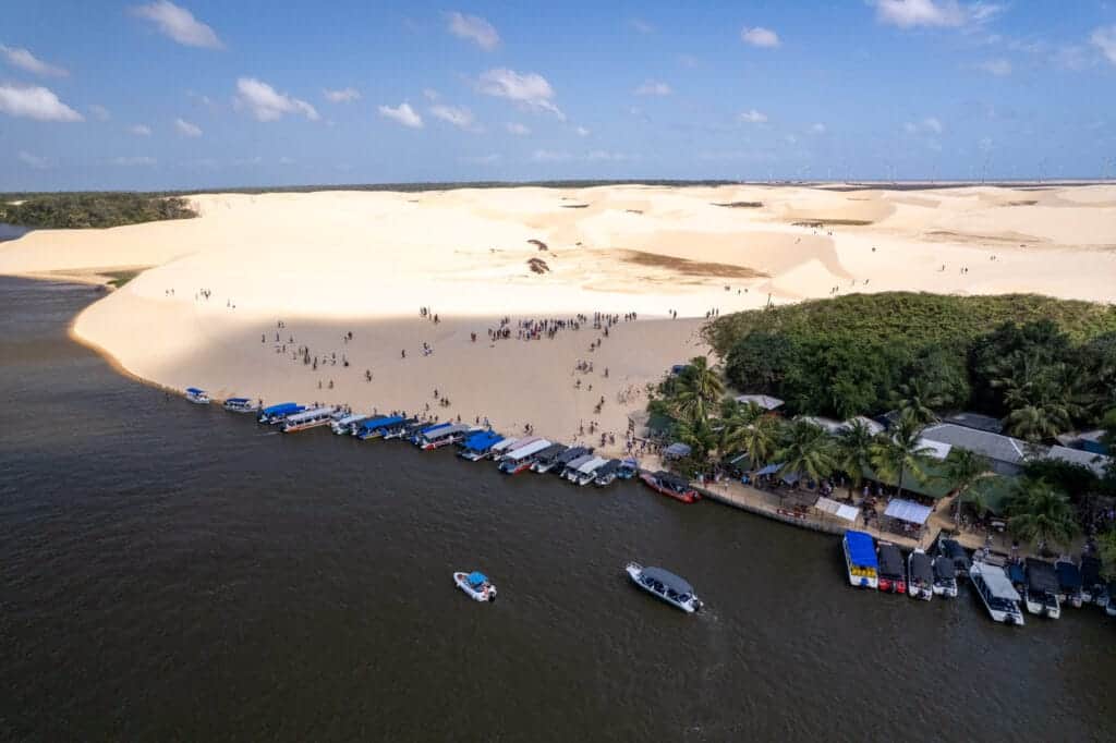 Aerial view of the Vassouras village with boats parking and tourist climbing on the dunes.