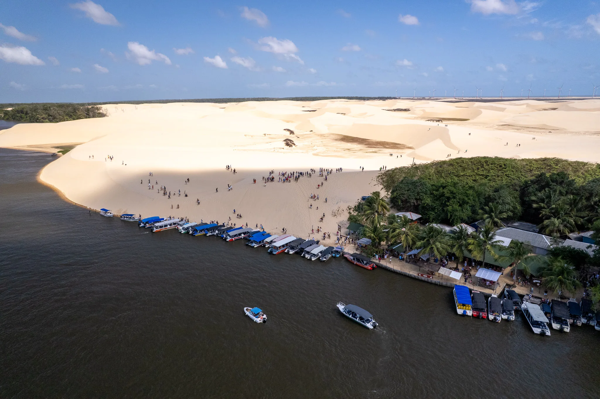 Aerial view of the Vassouras village with boats parking and tourist climbing on the dunes.