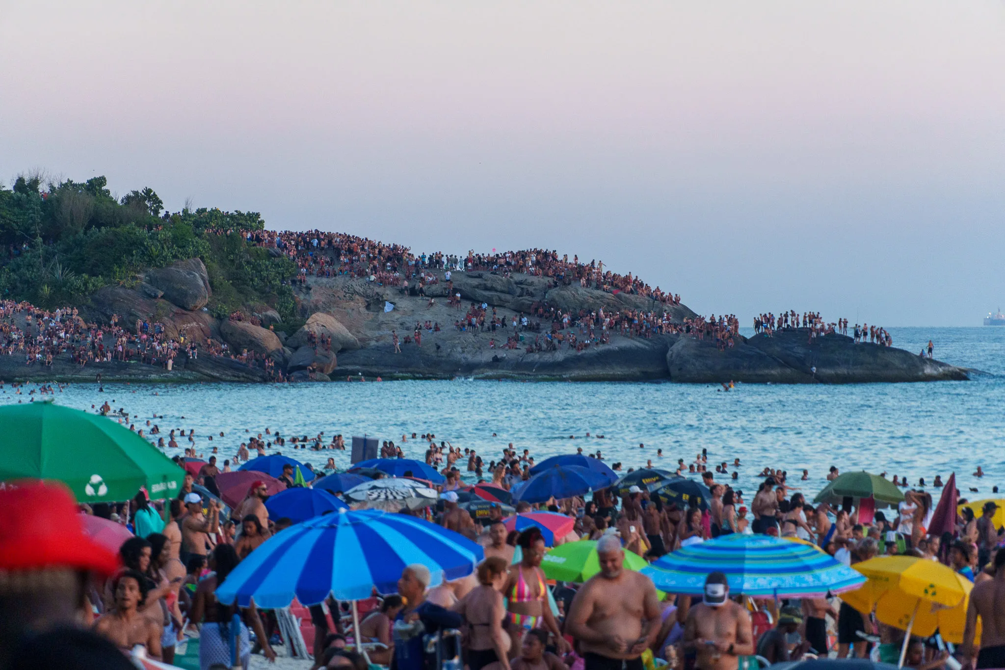 people on arpoador rock during the sunset, rio d ejaneiro, brazil.