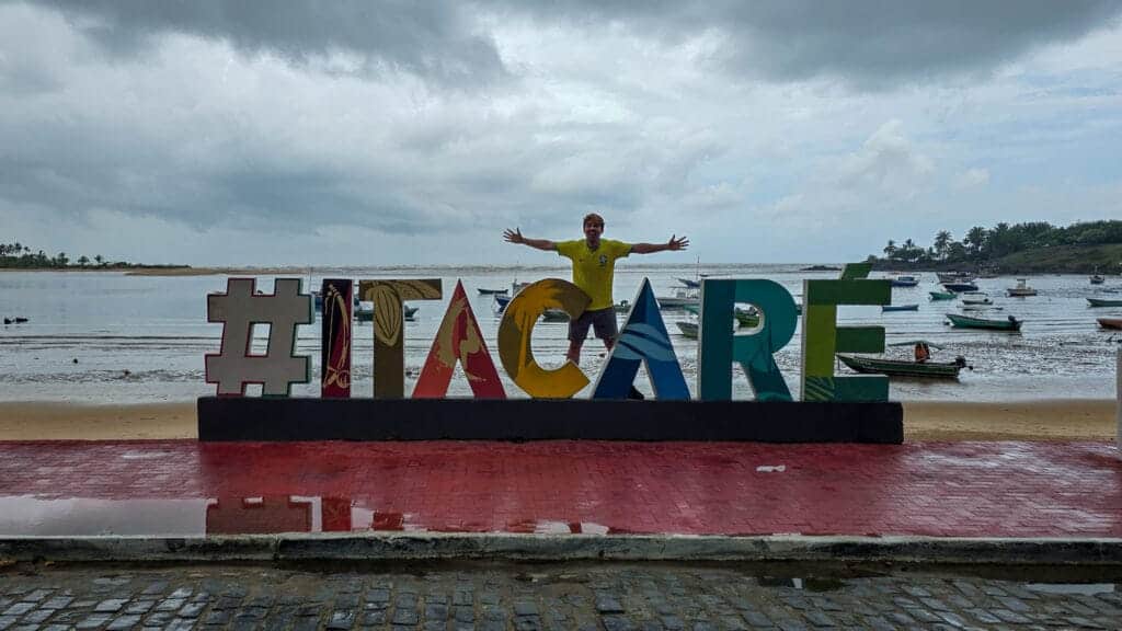 me (horizonhugo) in front of a big letter sculpture at Itacaré sating "#ITACARE"