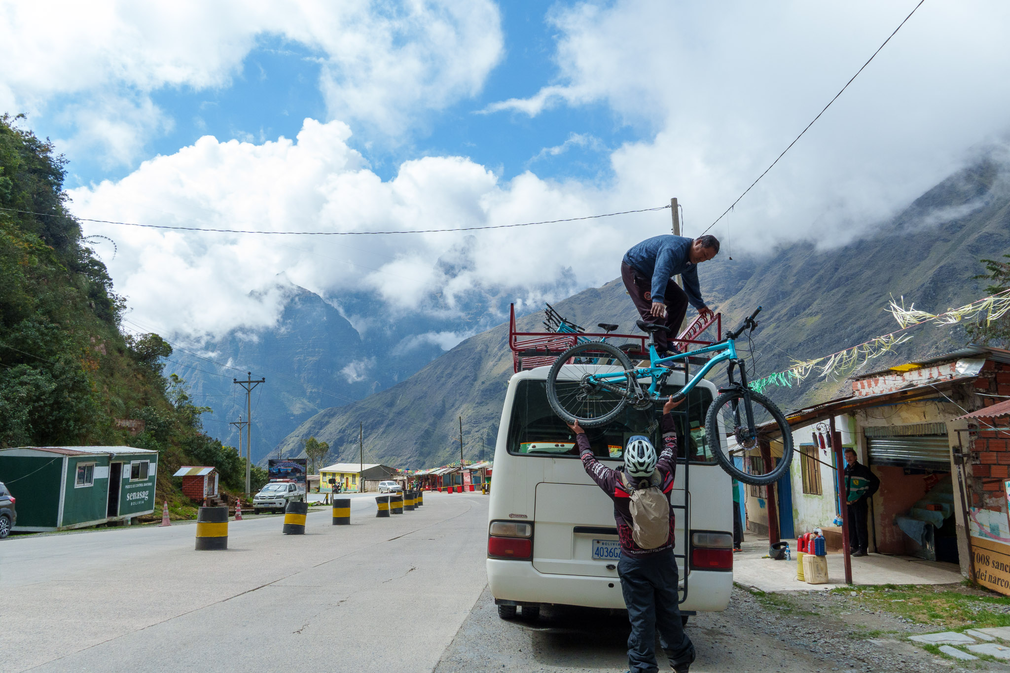 Gravity Bolivia Guides bringing back the bike on the top of the van to go from the first part of the Death Road to the second one.