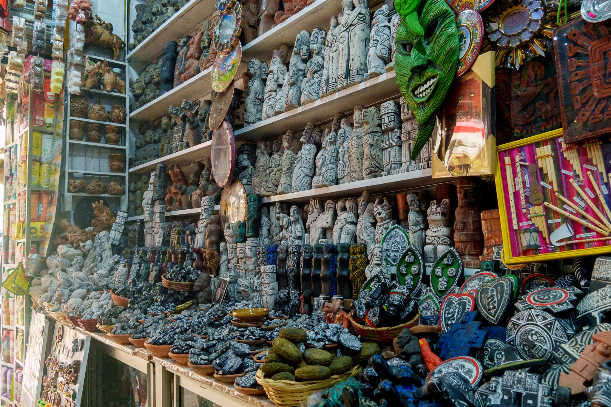 Inside of a shop at the witch market in La Paz. The wall is full of small statues and crafts that have 