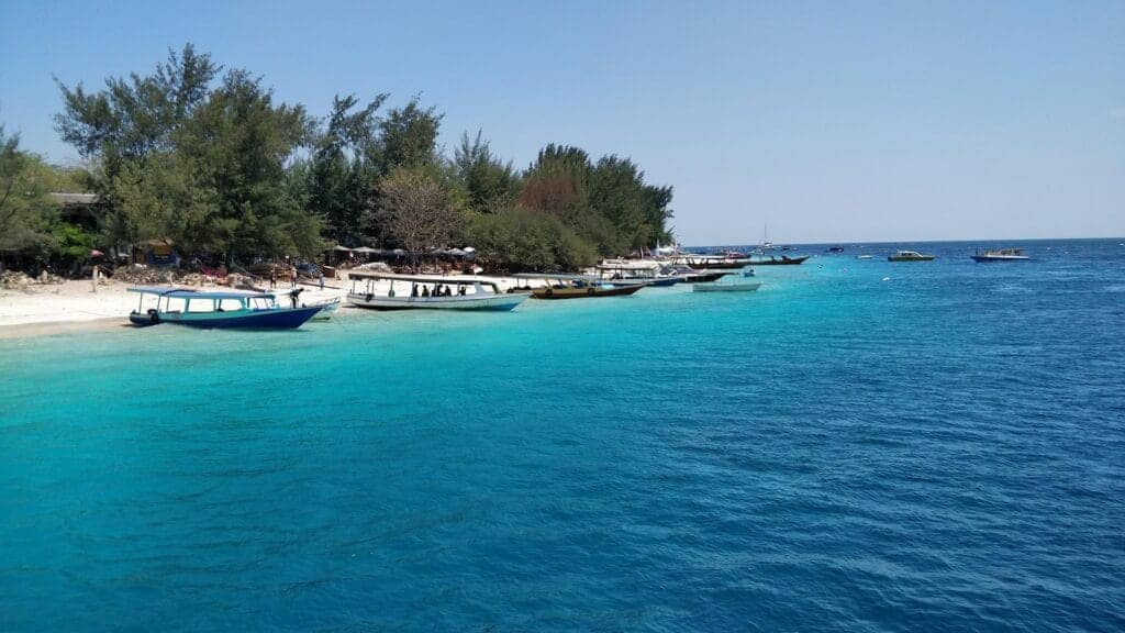 Boats atatched to the beach at Gili Trawangan island in Indonesia. the sea is beautiful blue.