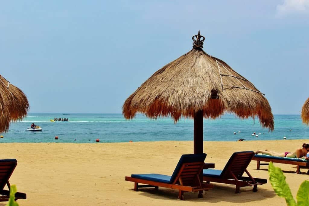 Beach with long chairs and parasol for tourist to come and relax all day at Nusa Dua, Bali, Indonesia.