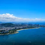 View from the plane of Rio d ejaneiro with a beautiful blue sky. We can see the buildings and the beach of copacabana.