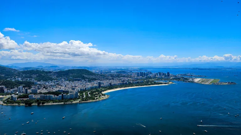 View from the plane of Rio d ejaneiro with a beautiful blue sky. We can see the buildings and the beach of copacabana.