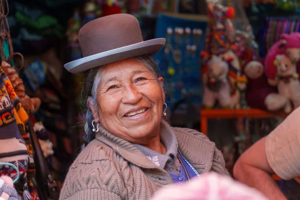 Portrait of a cholitas owning a souvenir shop in the touristic district of La Paz. She's wearing the traditional bombín bowler hat.