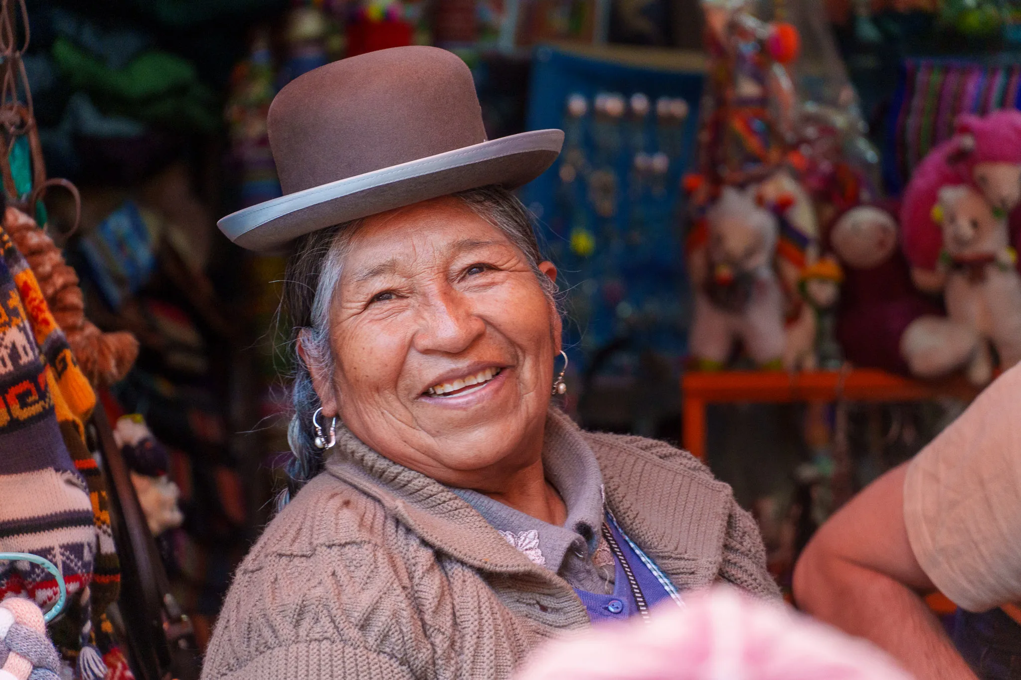 Portrait of a cholitas owning a souvenir shop in the touristic district of La Paz. She's wearing the traditional bombín bowler hat.