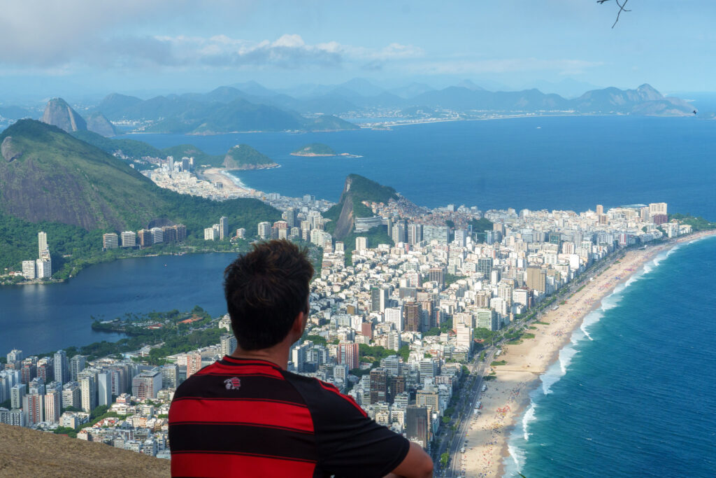 man in front of a viewpoint with the bay of ipanema in rio d ejaneiro, brazil.